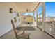 Covered patio with rocking chair, table, and neighborhood views creating an inviting outdoor living space at 2028 Ironstone Aly, Charleston, SC 29407