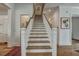 Elegant staircase with wood treads and white risers, complemented by hardwood flooring and white trim, offering a warm, inviting ambiance at 2028 Ironstone Aly, Charleston, SC 29407