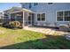 The backyard features a spacious stone patio off a screened porch and manicured shrubbery at 221 Waning Way, Charleston, SC 29492