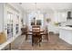 Bright dining area features elegant lighting, views of kitchen, and access to outdoor patio at 221 Waning Way, Charleston, SC 29492