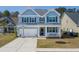Charming two-story home with light blue siding, white trim and a well-manicured lawn at 221 Waning Way, Charleston, SC 29492