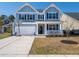 Two-story home with light blue siding and dark shutters, featuring a welcoming front porch at 221 Waning Way, Charleston, SC 29492