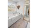Cozy bathroom with a soaking tub under a window and an artistic touch with a woven heart wall hanging at 221 Waning Way, Charleston, SC 29492