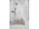 Elegant marble shower in a bathroom with pebble floor detail and a frameless glass door at 221 Waning Way, Charleston, SC 29492