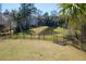 Landscaped backyard with black metal fence overlooking a serene pond and lush green trees at 2305 Sturgeon, Johns Island, SC 29455