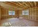 Unfinished room featuring exposed framing, two windows, and plywood subflooring ready for customization and finishing touches at 2379 Sorentrue Ave, North Charleston, SC 29405