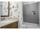 Bathroom with granite countertop, floral accent wall, and tub with shower at 2552 Josiah St, Daniel Island, SC 29492