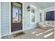 Charming front porch featuring wicker chairs, dark wood door, and 'hello' welcome mat, creating a cozy entrance at 2552 Josiah St, Daniel Island, SC 29492