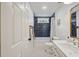 Bright bathroom featuring blue tiled shower and tub, a white sink vanity, and stylish gold fixtures at 3025 Penny Ln, Johns Island, SC 29455