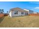 Spacious backyard with a well-maintained lawn, wooden fence, and views of neighboring houses under a clear sky at 316 Knawl Road, Moncks Corner, SC 29461