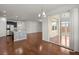 Open-concept living space with hardwood floors, kitchen with island, and sunroom access at 316 Knawl Road, Moncks Corner, SC 29461