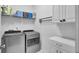 Well-equipped laundry room with modern washer, dryer, storage cabinets and wire shelving for organization at 3473 Plow Ground Rd, Johns Island, SC 29455