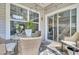 Cozy covered patio with wicker furniture, glass table, ceiling fan, and sliding glass door to the interior at 3473 Plow Ground Rd, Johns Island, SC 29455