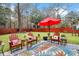 Relaxing backyard seating area with red patio umbrella, outdoor rug, and wooden furniture at 3545 Rookwood Pl, Johns Island, SC 29455