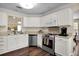Charming kitchen featuring white cabinets, stainless steel appliances, and rich wood flooring at 3545 Rookwood Pl, Johns Island, SC 29455