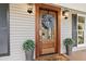 Elegant wood front door with glass pane, wreath, and decorative planters at 404 Black Oak Blvd, Summerville, SC 29485