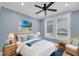 Cozy bedroom with beach art, a ceiling fan, and a window with white frame and white trim at 4070 Egret Perch Ct, Ravenel, SC 29470