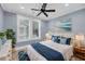 Cozy bedroom with beach art, a ceiling fan, and a window with white frame and white trim at 4070 Egret Perch Ct, Ravenel, SC 29470