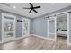 Bedroom featuring large windows, a ceiling fan, and ensuite bathroom with sliding barn door at 4070 Egret Perch Ct, Ravenel, SC 29470
