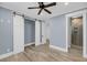 Bedroom featuring a ceiling fan, gray walls, plank flooring, and white barn doors to the bathroom at 4070 Egret Perch Ct, Ravenel, SC 29470