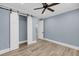 Bedroom featuring a ceiling fan, gray walls, plank flooring, and white barn doors at 4070 Egret Perch Ct, Ravenel, SC 29470