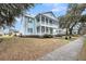 Beautiful two-story home featuring a charming double-decker porch, surrounded by a well-manicured lawn at 4070 Egret Perch Ct, Ravenel, SC 29470