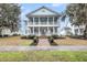 Inviting two-story home featuring a spacious double-decker porch, manicured lawn, and charming curb appeal at 4070 Egret Perch Ct, Ravenel, SC 29470