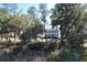 Charming two-story home with a balcony, seen amidst a lush landscape of trees and greenery at 4070 Egret Perch Ct, Ravenel, SC 29470