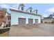 Detached three-car garage featuring dormer windows, gray carriage doors, and ample parking space at 4070 Egret Perch Ct, Ravenel, SC 29470