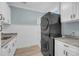 Laundry room featuring modern washer and dryer set and white cabinets with a stone countertop and plank flooring at 4070 Egret Perch Ct, Ravenel, SC 29470