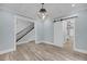 Spacious living area featuring wood floors, a modern light fixture, and a staircase with an iron railing at 4070 Egret Perch Ct, Ravenel, SC 29470