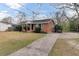 Charming single-story brick home with a long driveway and ramp all under a blue sky backdrop at 4203 Marilyn Dr, North Charleston, SC 29418