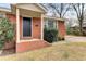 A charming front porch featuring brick columns, a black front door, and manicured shrubs at 4203 Marilyn Dr, North Charleston, SC 29418