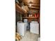 Functional laundry room area with washer, dryer, hot water tank, and storage shelving at 4203 Marilyn Dr, North Charleston, SC 29418