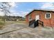 Rear view of a single-story brick home with a ramp leading to the back door and a large concrete patio at 4203 Marilyn Dr, North Charleston, SC 29418