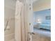 View from the shower with a shower curtain into a bright bedroom with a bed, side table, and access to a balcony at 482 Sea Cloud Cir, Edisto Island, SC 29438