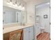 Well-lit bathroom with a vanity area, wood-look floors, white cabinets, and a separate toilet area for added privacy at 482 Sea Cloud Cir, Edisto Island, SC 29438