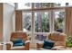Cozy seating area with comfortable chairs, throw pillows, large windows, and views to the beautiful greenery outside at 482 Sea Cloud Cir, Edisto Island, SC 29438
