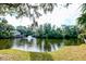 Scenic view of a tranquil pond with a fountain, framed by lush trees and greenery at 482 Sea Cloud Cir, Edisto Island, SC 29438