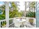 Inviting porch with white table, chairs, and scenic views of lush greenery and tranquil water at 482 Sea Cloud Cir, Edisto Island, SC 29438