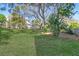 Lush backyard with mature trees casting shadows on the lawn at 502 W Ashley Ave, Folly Beach, SC 29439