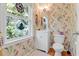 Bathroom with floral wallpaper, stained-glass window, and a white single-sink vanity at 502 W Ashley Ave, Folly Beach, SC 29439