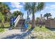 Beach access stairs framed by lush palm trees with informational signs on a sunny day at 502 W Ashley Ave, Folly Beach, SC 29439