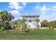 Charming three-story home with multiple balconies, set amidst lush greenery and a vibrant blue sky at 502 W Ashley Ave, Folly Beach, SC 29439