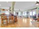 Open-concept living area with a bar, dining table, wood floors, and natural light at 502 W Ashley Ave, Folly Beach, SC 29439