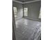 A view into a cozy bedroom, featuring gray carpet and three bright windows at 6201 Drayton St, Ravenel, SC 29470