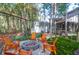 Relaxing backyard featuring a cozy firepit with Adirondack chairs, artificial grass and lush greenery at 635 Fair Spring Dr, Charleston, SC 29414