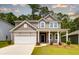 Charming two-story home featuring a covered porch, two-car garage and a well-maintained lawn at 743 Meadowbrook Ln, Summerville, SC 29486