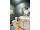 Charming bathroom with shiplap walls, hardwood floors, and a round mirror above the sink at 744 Gate Post Dr, Mount Pleasant, SC 29464