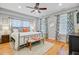 Stylish bedroom with hardwood floors, rug, bed bench, modern ceiling fan, and patterned drapes at 744 Gate Post Dr, Mount Pleasant, SC 29464